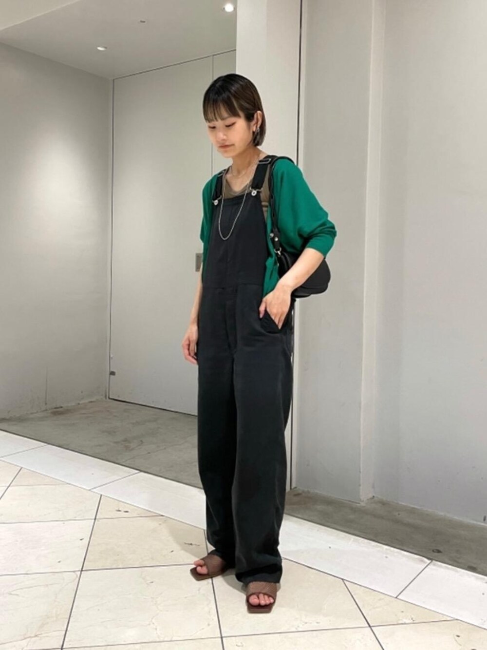 ブラウン系のサンダル、ブラック系のショルダーバッグ、グリーン系のカーディガン/ボレロを着用したレディースの夏コーディネートの1枚目の写真