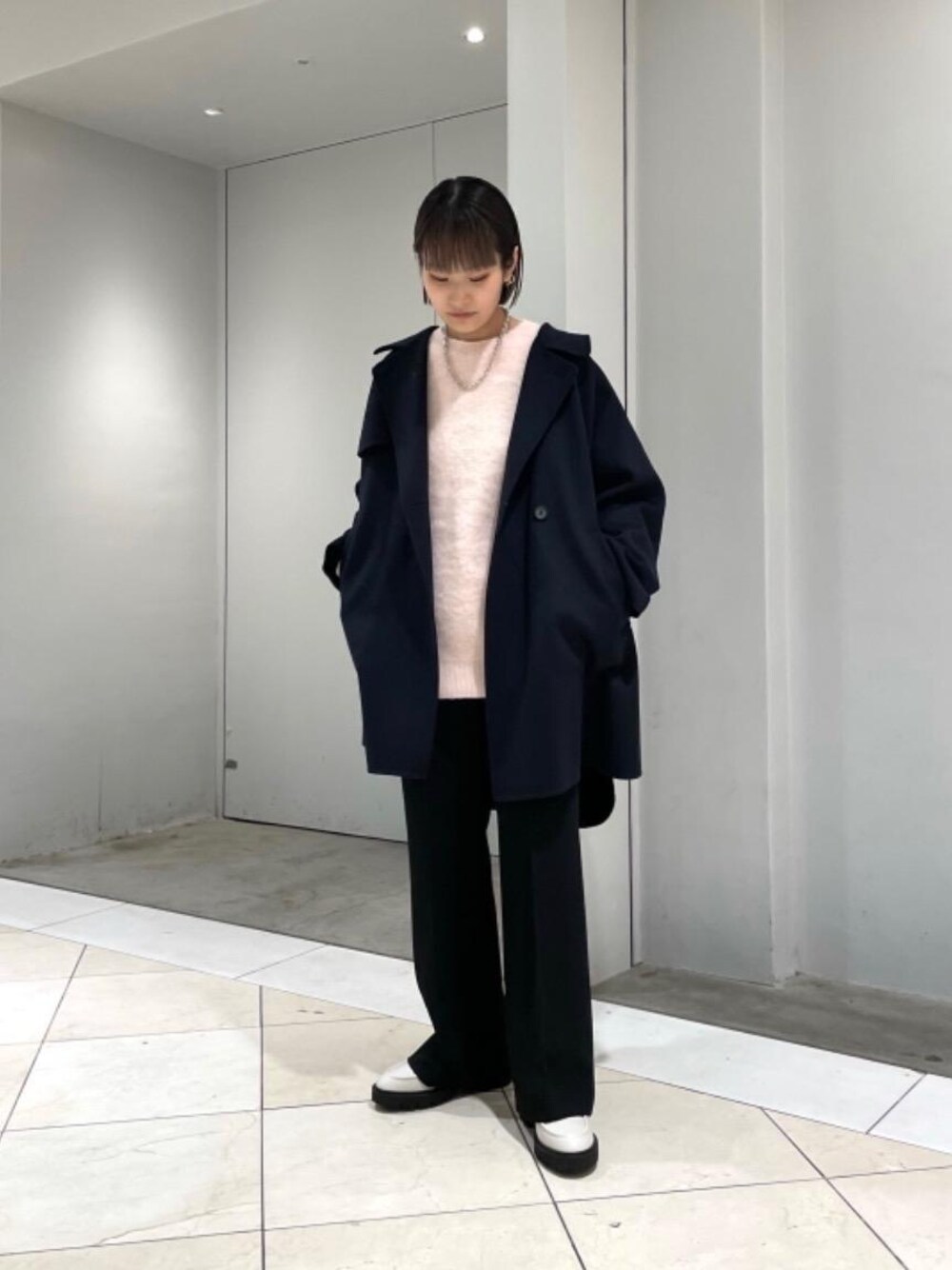 ホワイト系のローファー、ブルー系のポンチョ、ブラック系のその他パンツを着用したレディースの秋コーディネートの1枚目の写真