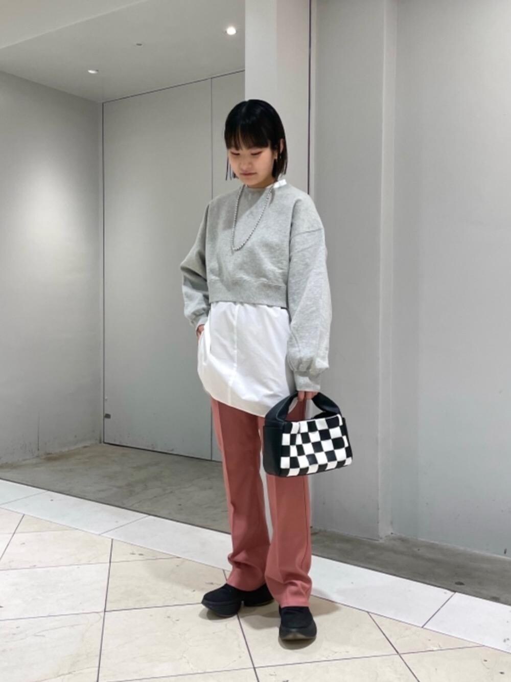 グレー系のスウェット、ブラック系のハンドバッグ、ホワイト系のシャツ/ブラウスを着用したレディースの冬コーディネートの1枚目の写真