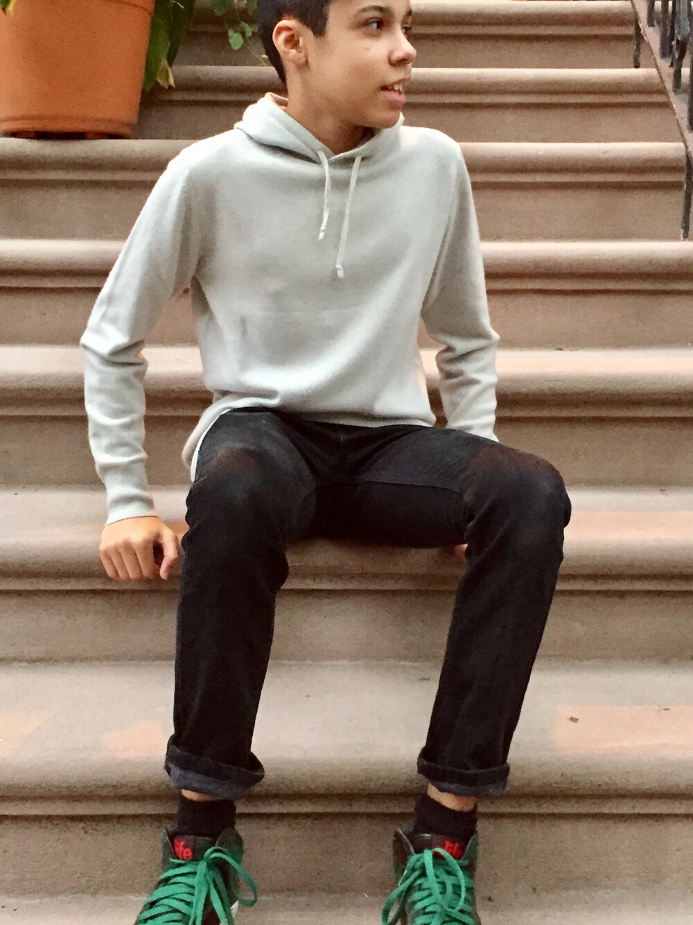 グレー系のパーカー、ブラック系のデニムパンツ、その他のスニーカーを着用したキッズの秋コーディネートの1枚目の写真