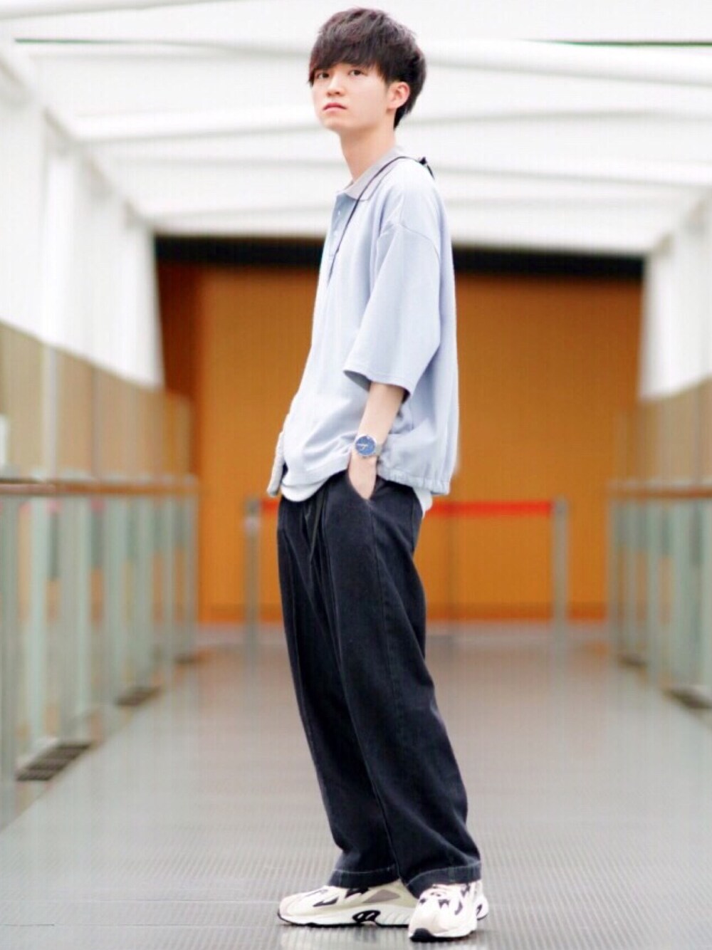 ブルー系のポロシャツ、ホワイト系のタンクトップ、ホワイト系のスニーカーを着用したメンズの夏コーディネートの1枚目の写真