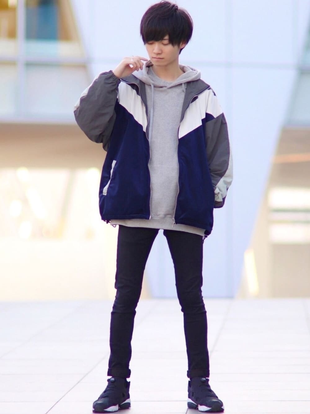 ブルー系のナイロンジャケット、グレー系のパーカー、ブラック系のその他パンツを着用したメンズの秋コーディネートの1枚目の写真