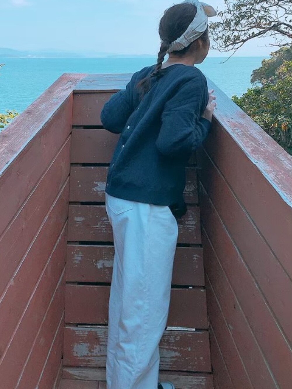 ブルー系のカーディガン/ボレロ、ホワイト系のデニムパンツ、ブラック系のスニーカーを着用したレディースの冬コーディネートの1枚目の写真