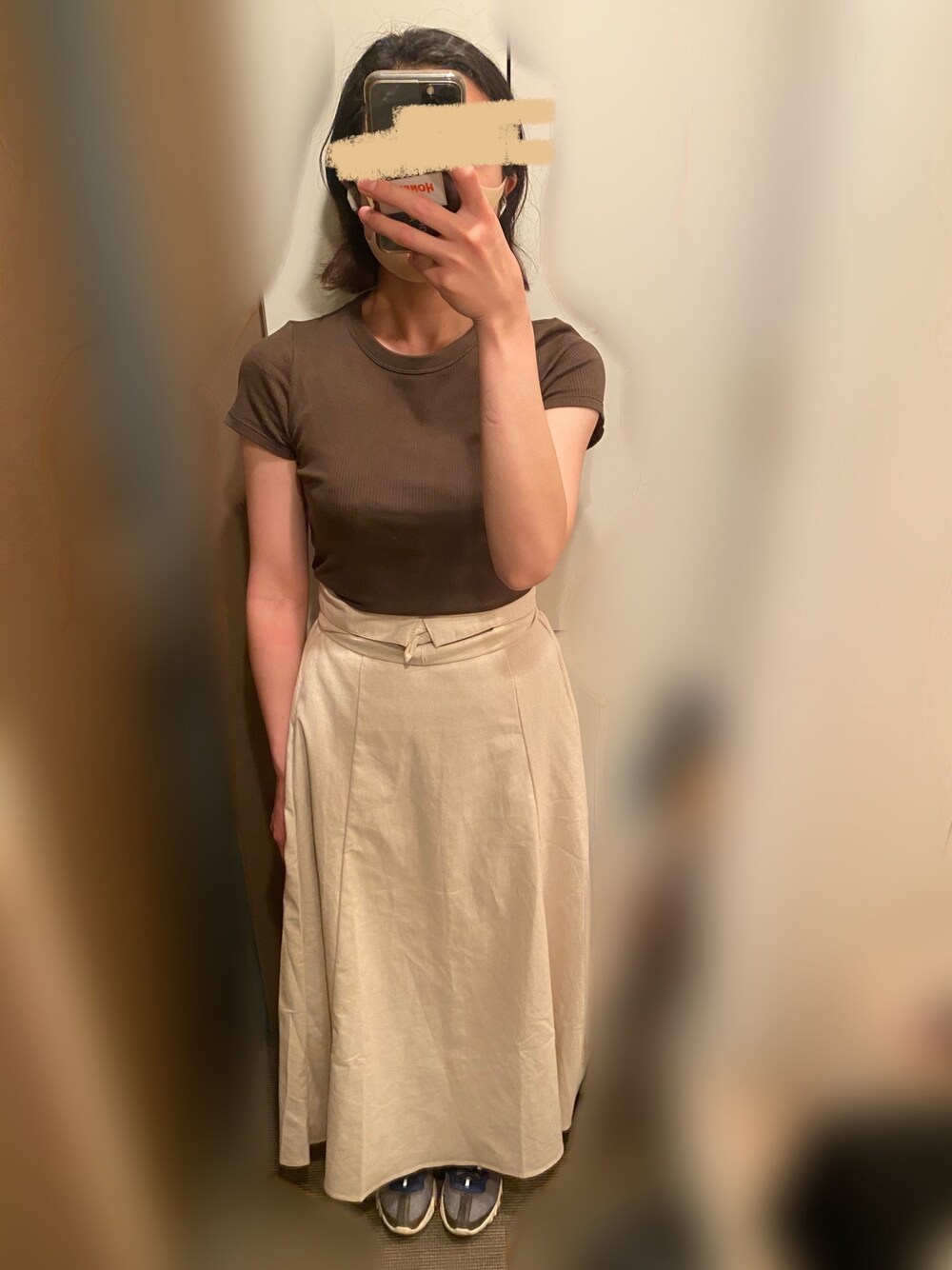 グリーン系のTシャツ/カットソー、ベージュ系のスカート、ブルー系のスニーカーを着用したレディースの夏コーディネートの1枚目の写真