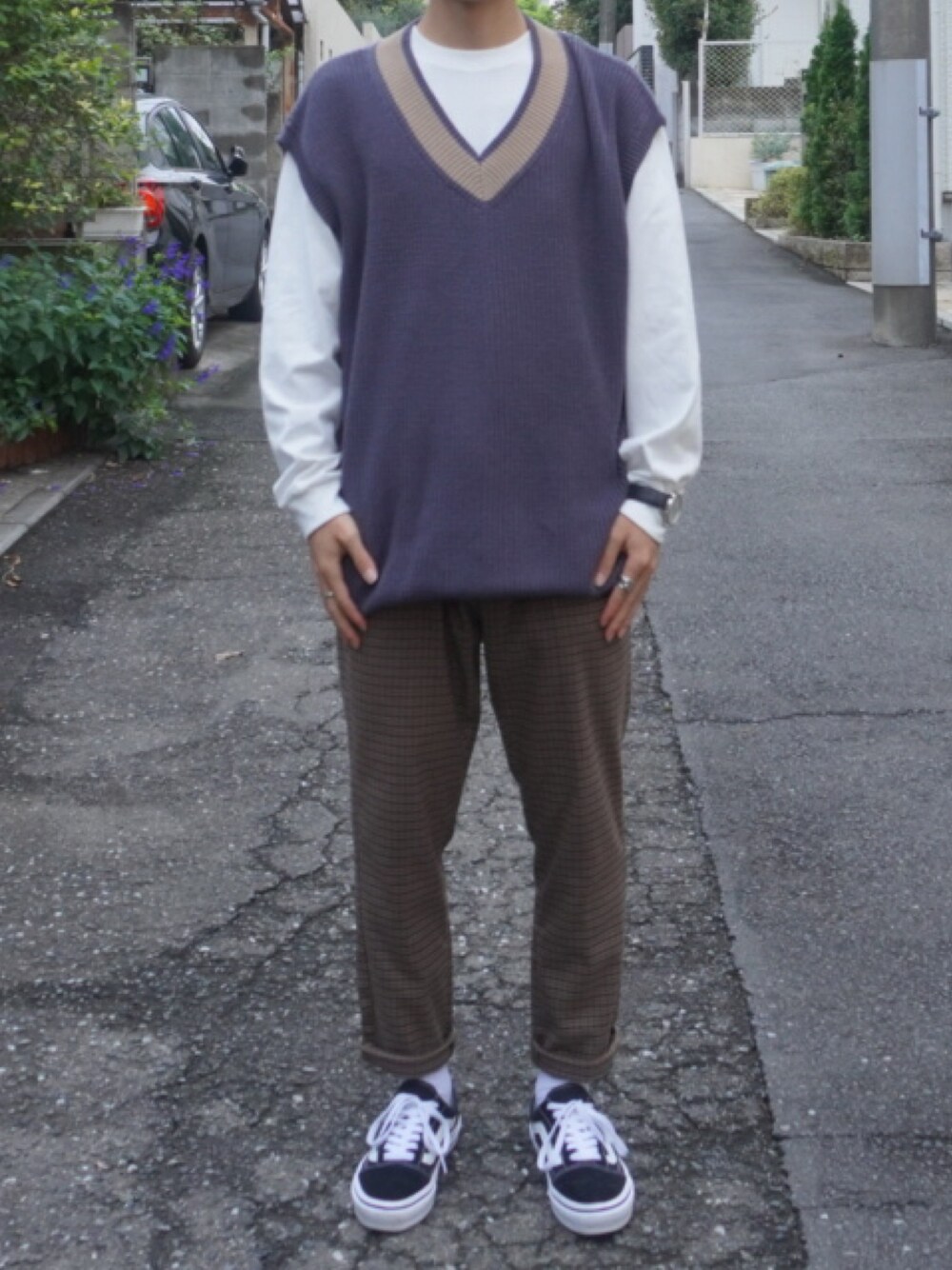 ブルー系のベスト、ホワイト系のTシャツ/カットソー、ブラウン系のスラックスを着用したメンズの秋コーディネートの1枚目の写真
