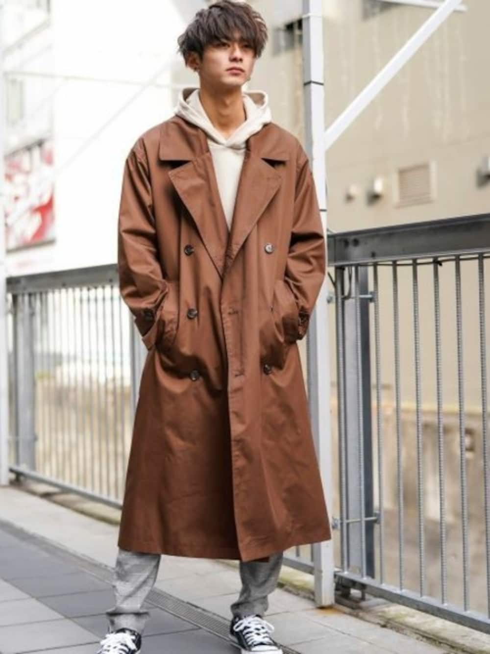 ブラウン系のトレンチコート、ベージュ系のパーカー、グレー系のその他パンツを着用したメンズの冬コーディネートの1枚目の写真