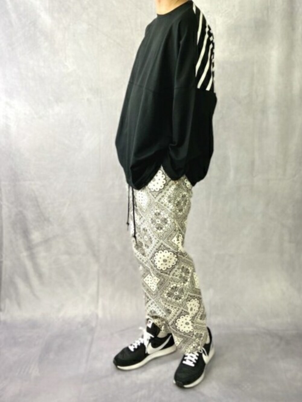 ブラック系のTシャツ/カットソー、ホワイト系のその他パンツを着用したメンズの秋コーディネートの1枚目の写真