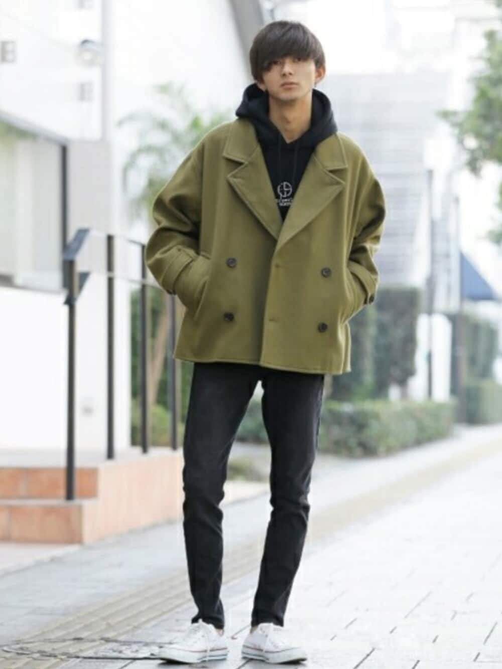 グリーン系のトレンチコート、ブラック系のパーカーを着用したメンズの冬コーディネートの1枚目の写真