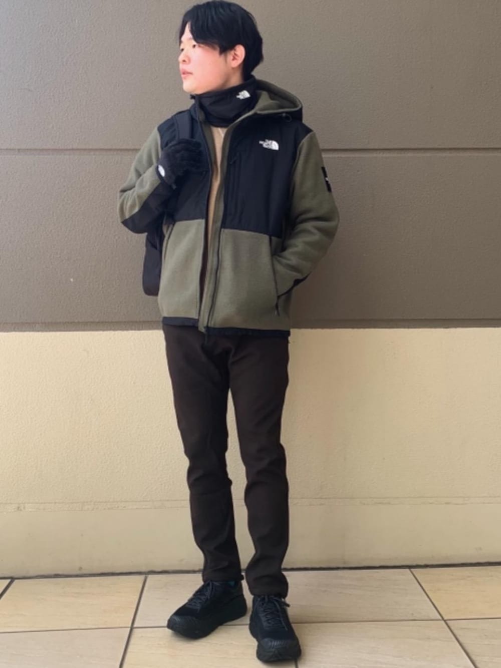 ブラウン系のその他パンツ、ブラック系のスニーカー、ブラック系のビジネスバッグを着用したメンズの冬コーディネートの1枚目の写真