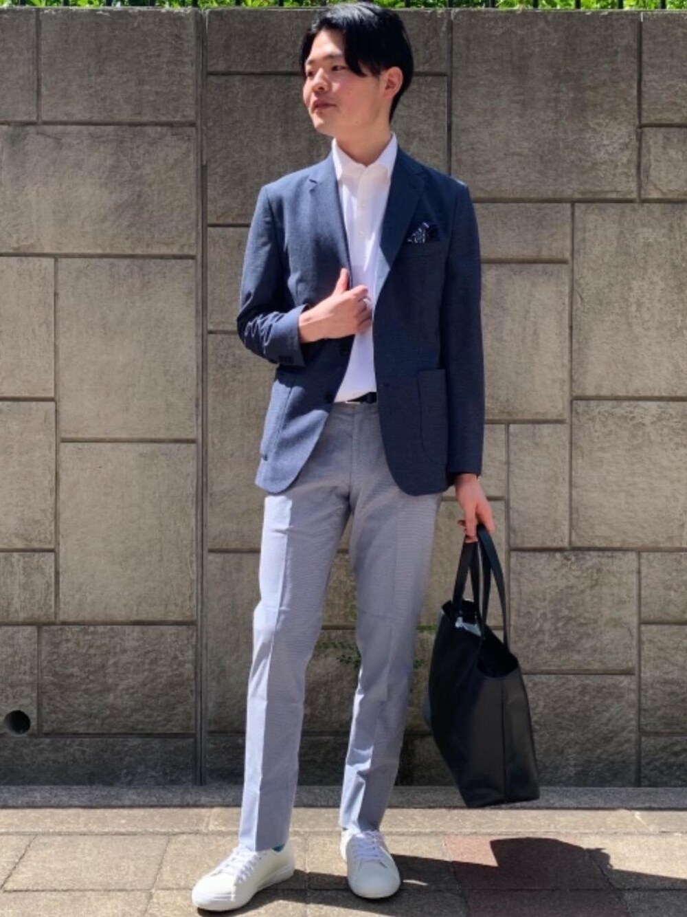 ブルー系のトートバッグ、ホワイト系のスニーカー、ホワイト系のポロシャツを着用したメンズの春コーディネートの1枚目の写真