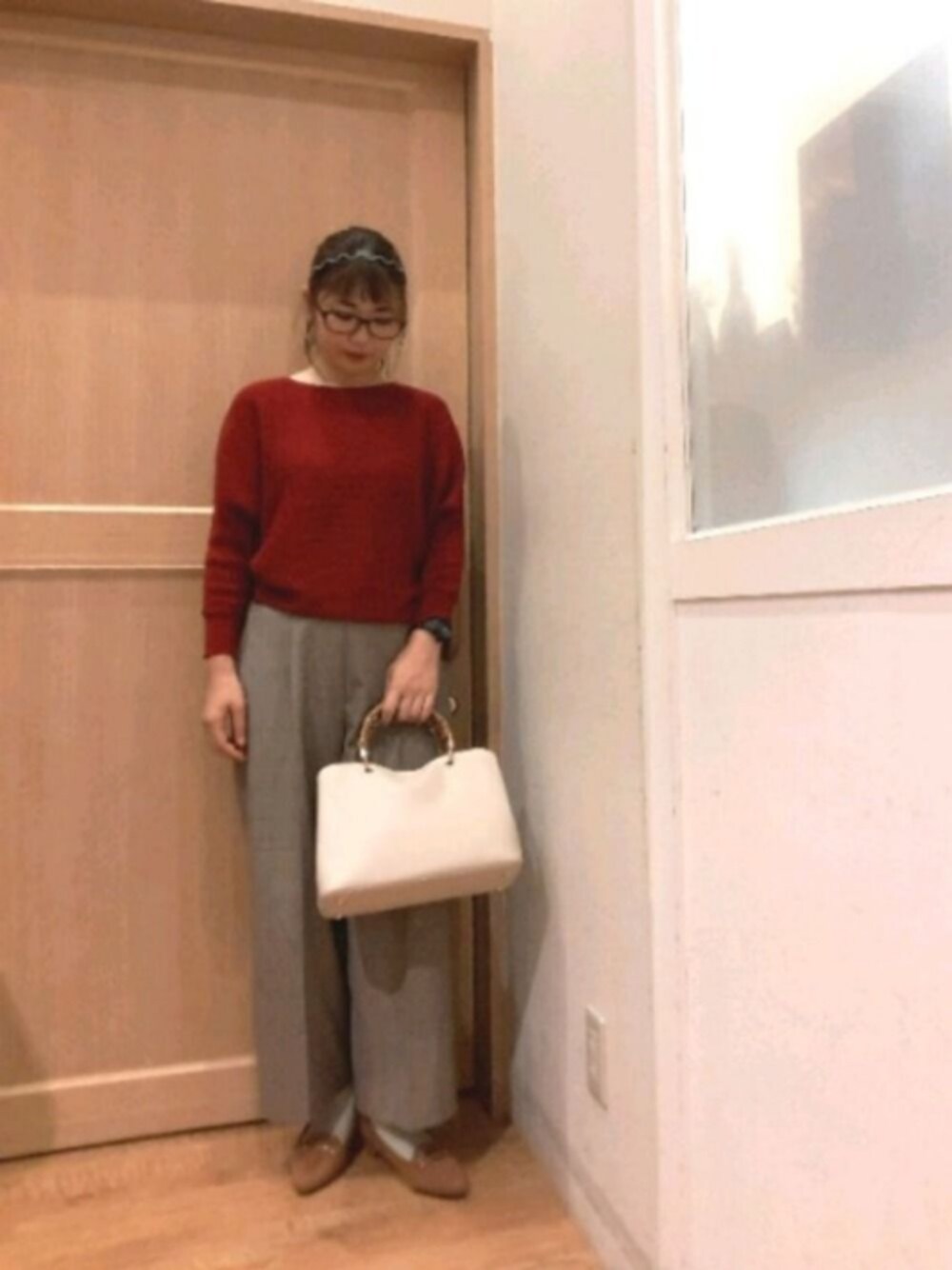 レッド系のニット/セーター、ベージュ系のその他パンツ、ベージュ系のトートバッグを着用したレディースの秋コーディネートの1枚目の写真