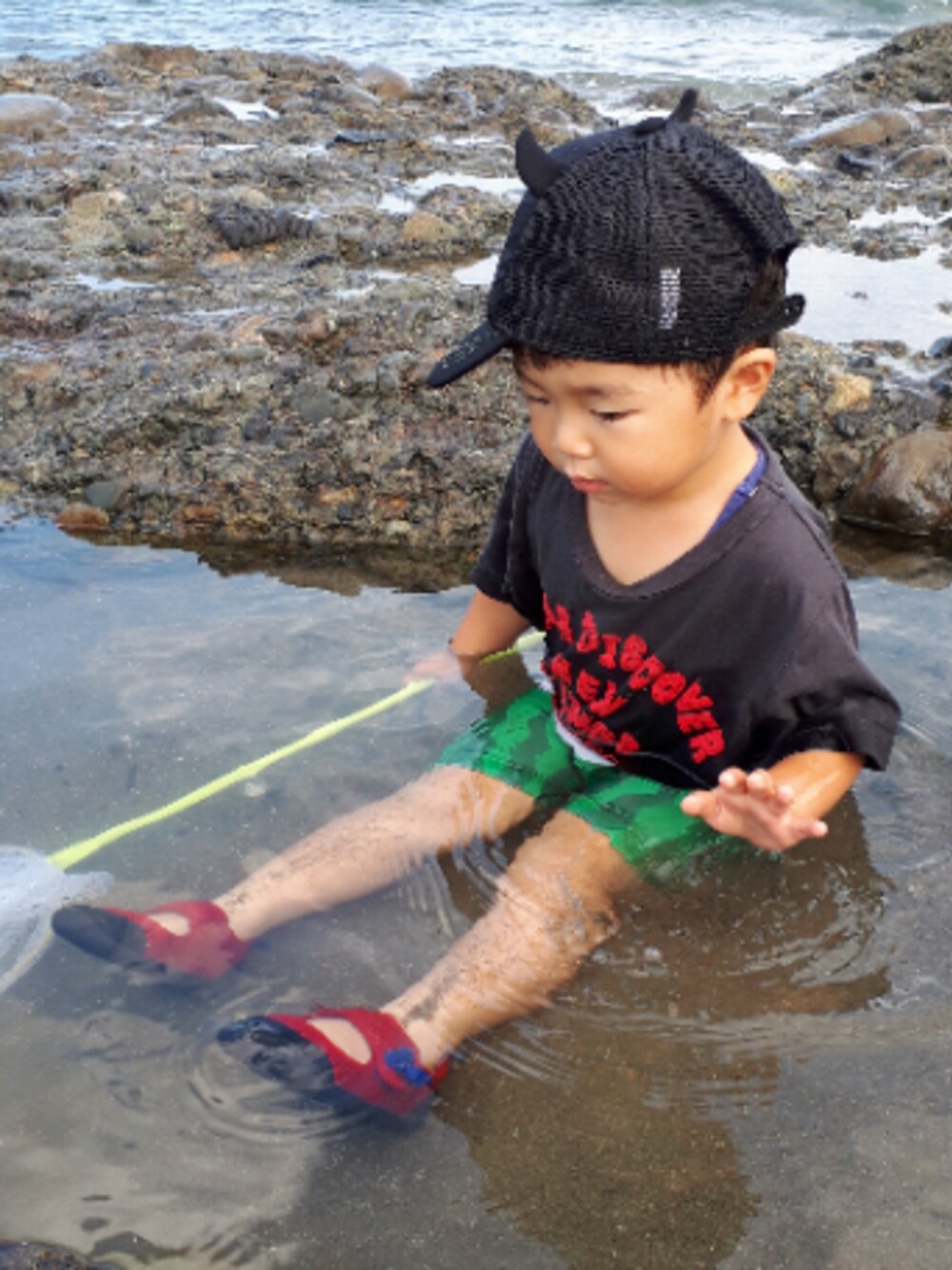 レッド系のスニーカー、グレー系のTシャツ/カットソー、ブラック系のキャップを着用したキッズの秋コーディネートの1枚目の写真