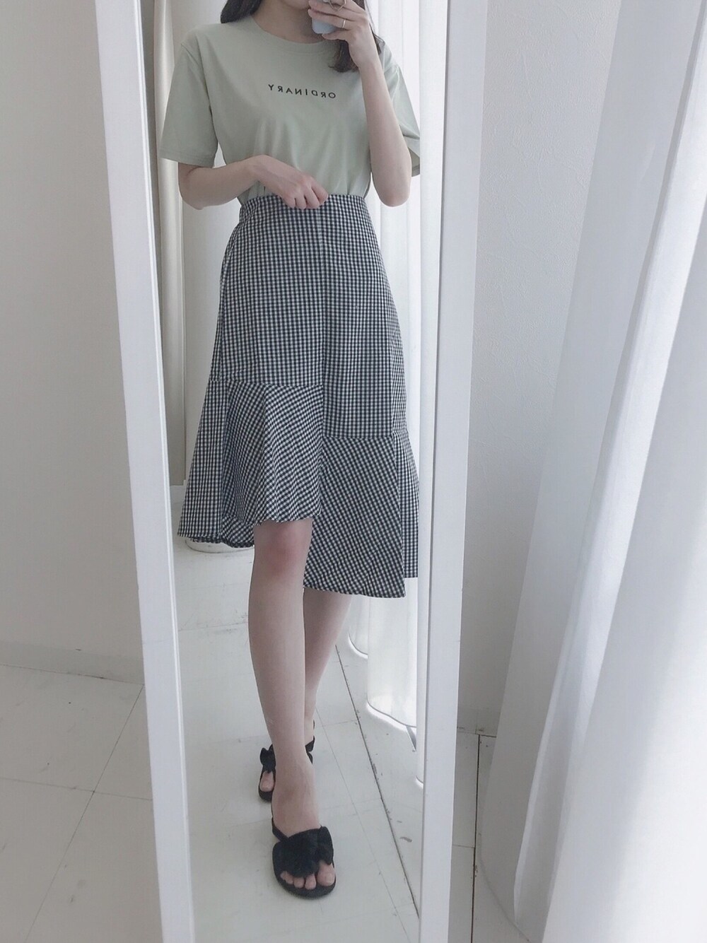 グリーン系のTシャツ/カットソー、ブラック系のスカート、ブラック系のサンダルを着用したレディースの夏コーディネートの1枚目の写真