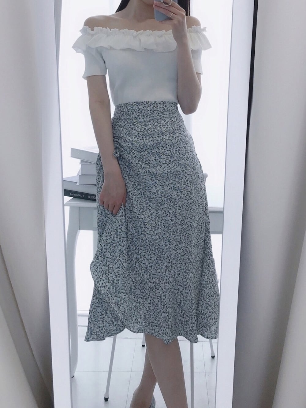 ブルー系のスカート、ホワイト系のニット/セーターを着用したレディースの夏コーディネートの1枚目の写真