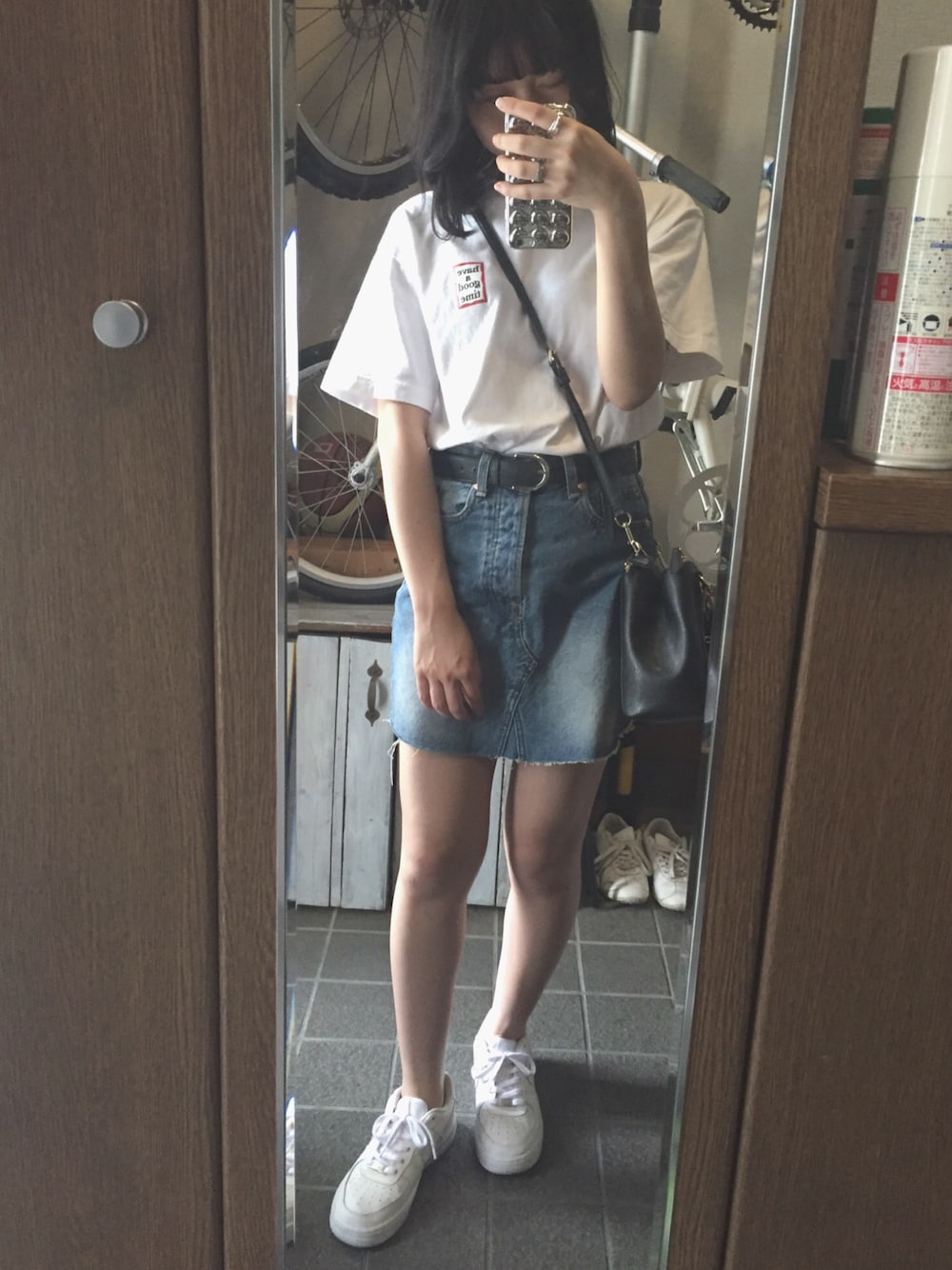 ホワイト系のTシャツ/カットソー、ブルー系のデニムスカート、ホワイト系のスニーカーを着用したレディースの夏コーディネートの1枚目の写真