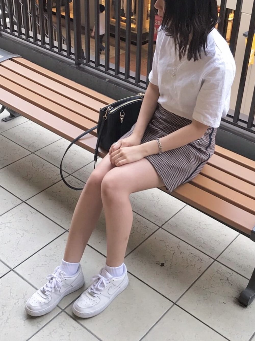 ホワイト系のTシャツ/カットソー、ブラウン系のスカート、ホワイト系のスニーカーを着用したレディースの秋コーディネートの1枚目の写真