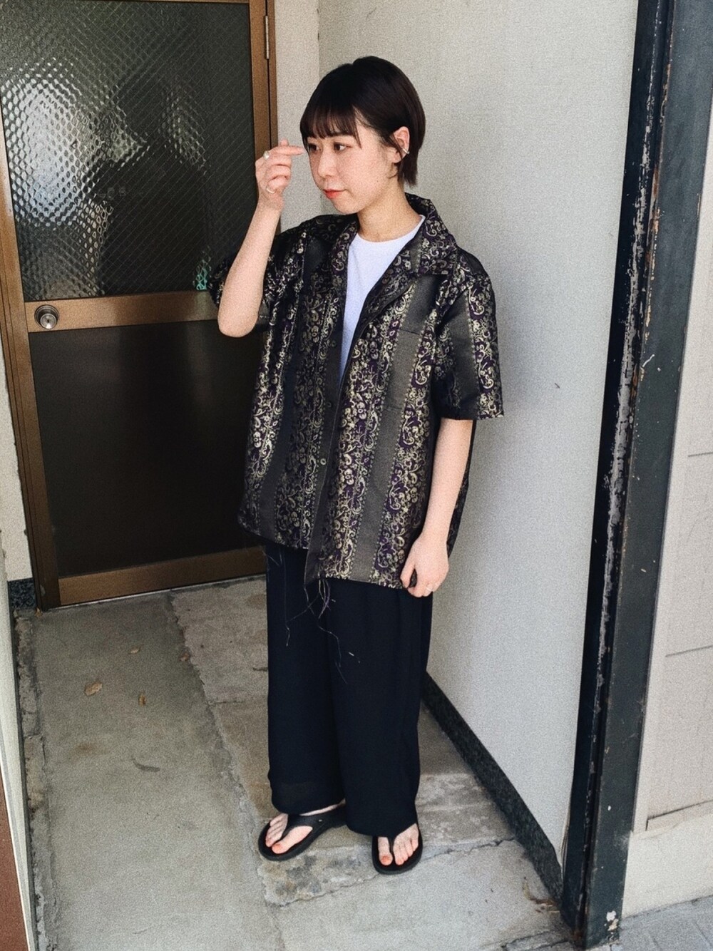 パープル系のシャツ/ブラウス、ブラック系のパンツ、ブラック系のサンダルを着用したレディースの春コーディネートの1枚目の写真