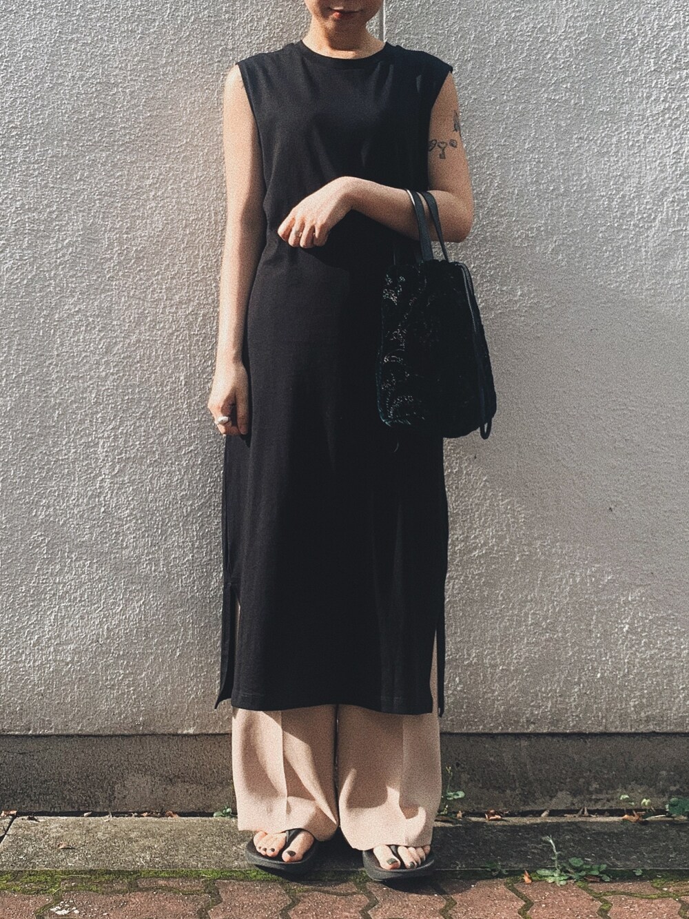 グリーン系のバッグ、ベージュ系のその他パンツ、ブラック系のワンピースを着用したレディースの夏コーディネートの1枚目の写真