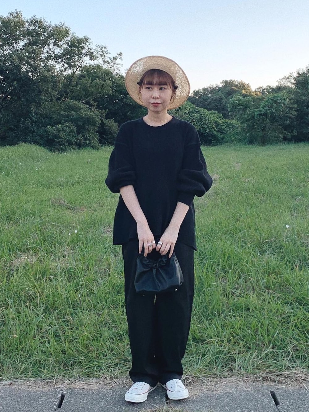 ブラック系のTシャツ/カットソー、ブラック系のハンドバッグ、ホワイト系のスニーカーを着用したレディースの秋コーディネートの1枚目の写真