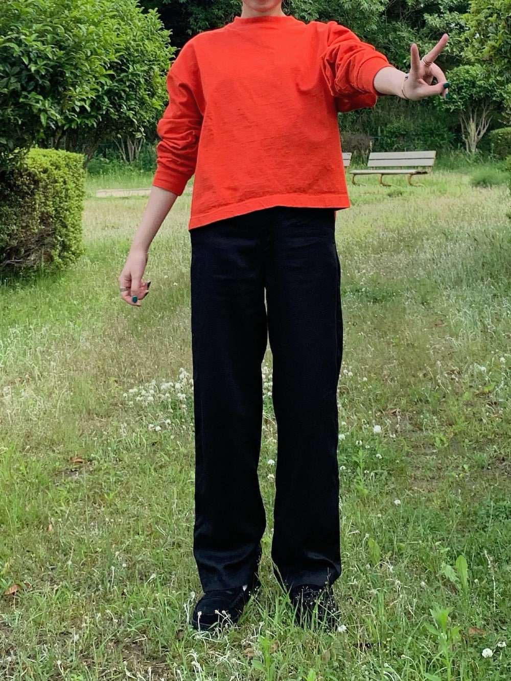 ブラック系のパンツ、ブラック系のローファー、レッド系のTシャツ/カットソーを着用したレディースの春コーディネートの1枚目の写真