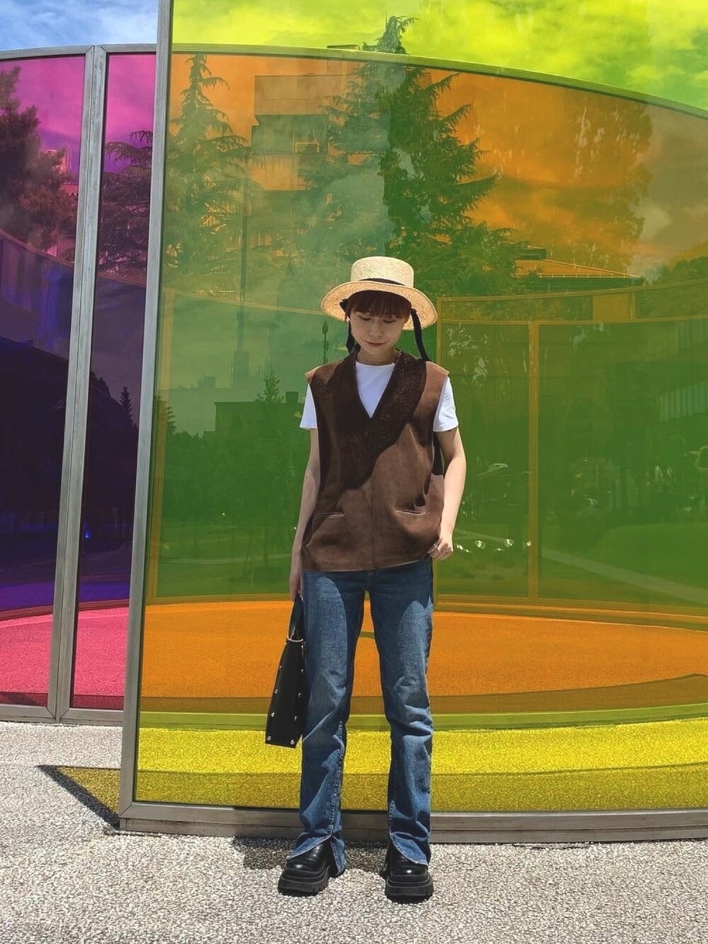 ブルー系のデニムパンツ、ブラウン系のベスト、ベージュ系のハットを着用したレディースの夏コーディネートの1枚目の写真