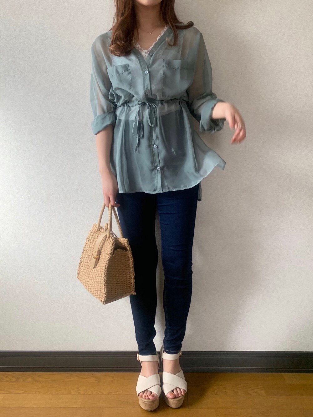 グリーン系のシャツ/ブラウス、ホワイト系のタンクトップ、ブルー系のデニムパンツを着用したレディースの春コーディネートの1枚目の写真