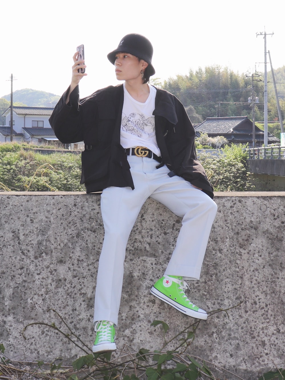 ブラック系のその他アウター、ホワイト系のTシャツ/カットソー、グレー系のチノパンツを着用したメンズの春コーディネートの1枚目の写真