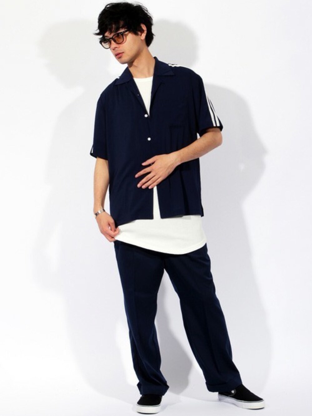 ホワイト系のタンクトップ、ブルー系のスラックス、ブラック系のベルトを着用したメンズの春コーディネートの1枚目の写真