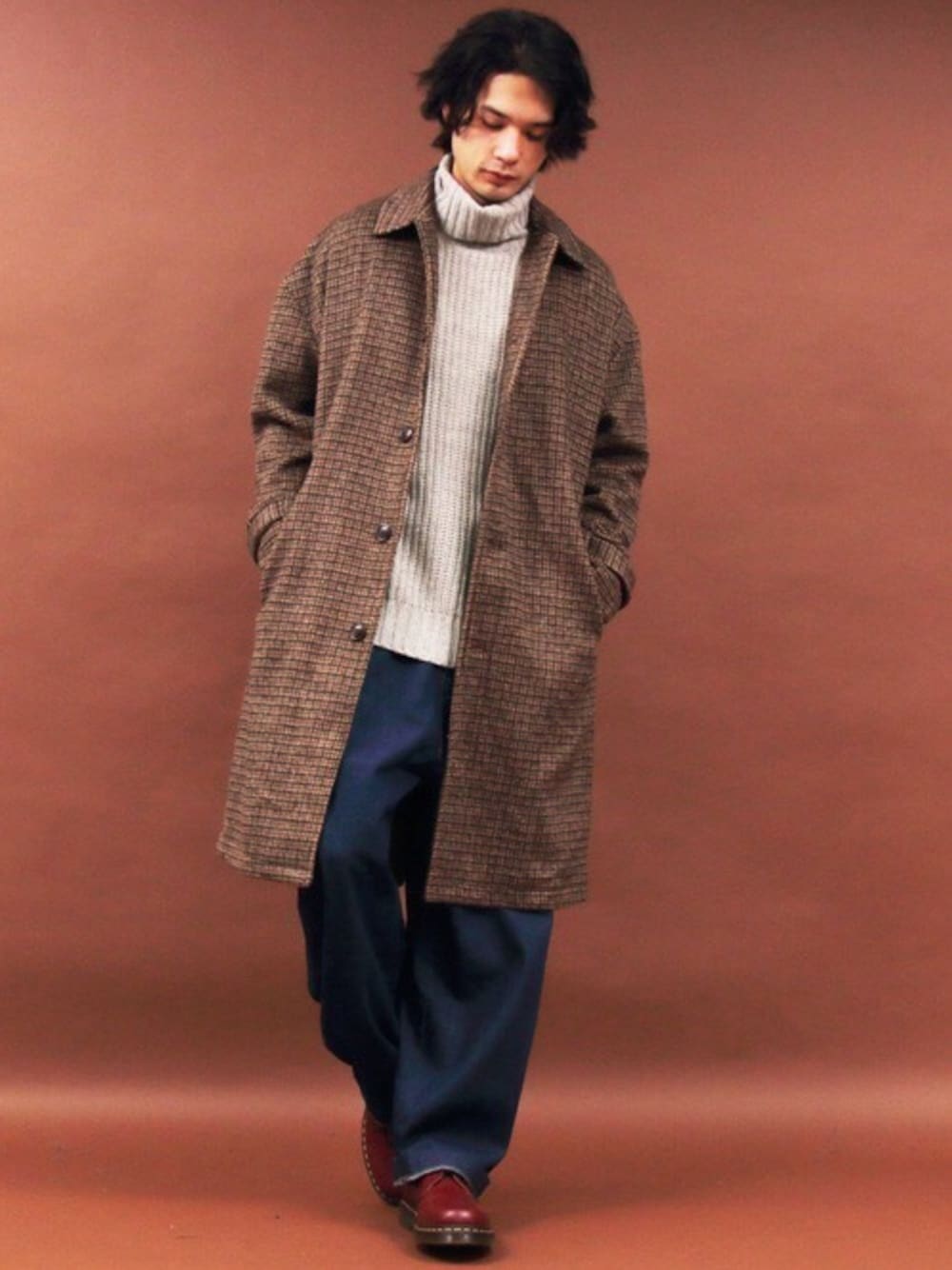 ベージュ系のニット/セーター、ホワイト系のTシャツ/カットソー、ブルー系のデニムパンツを着用したメンズの冬コーディネートの1枚目の写真