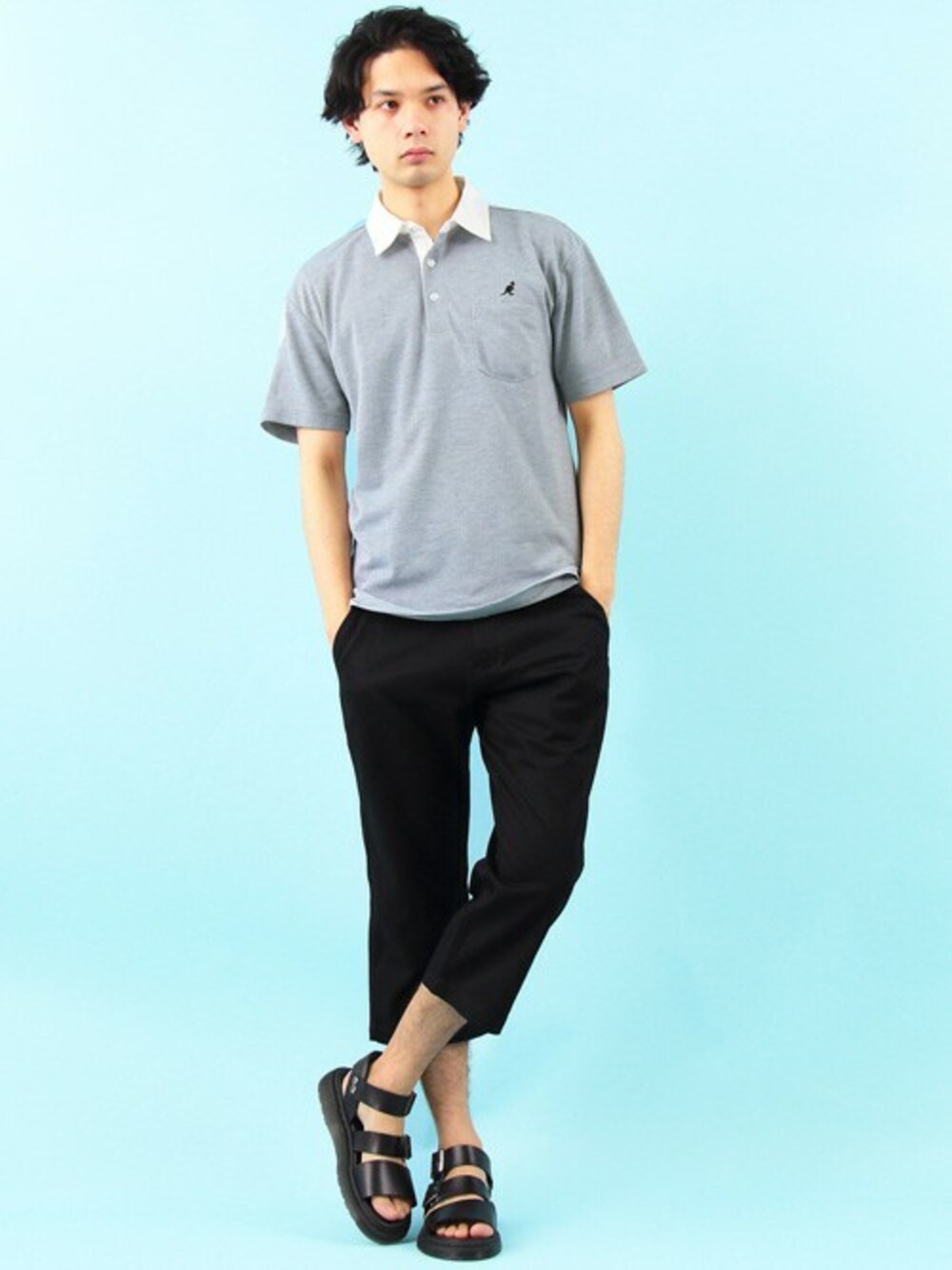 グレー系のポロシャツ、ブラック系のタンクトップ、ブラック系のチノパンツを着用したメンズの夏コーディネートの1枚目の写真