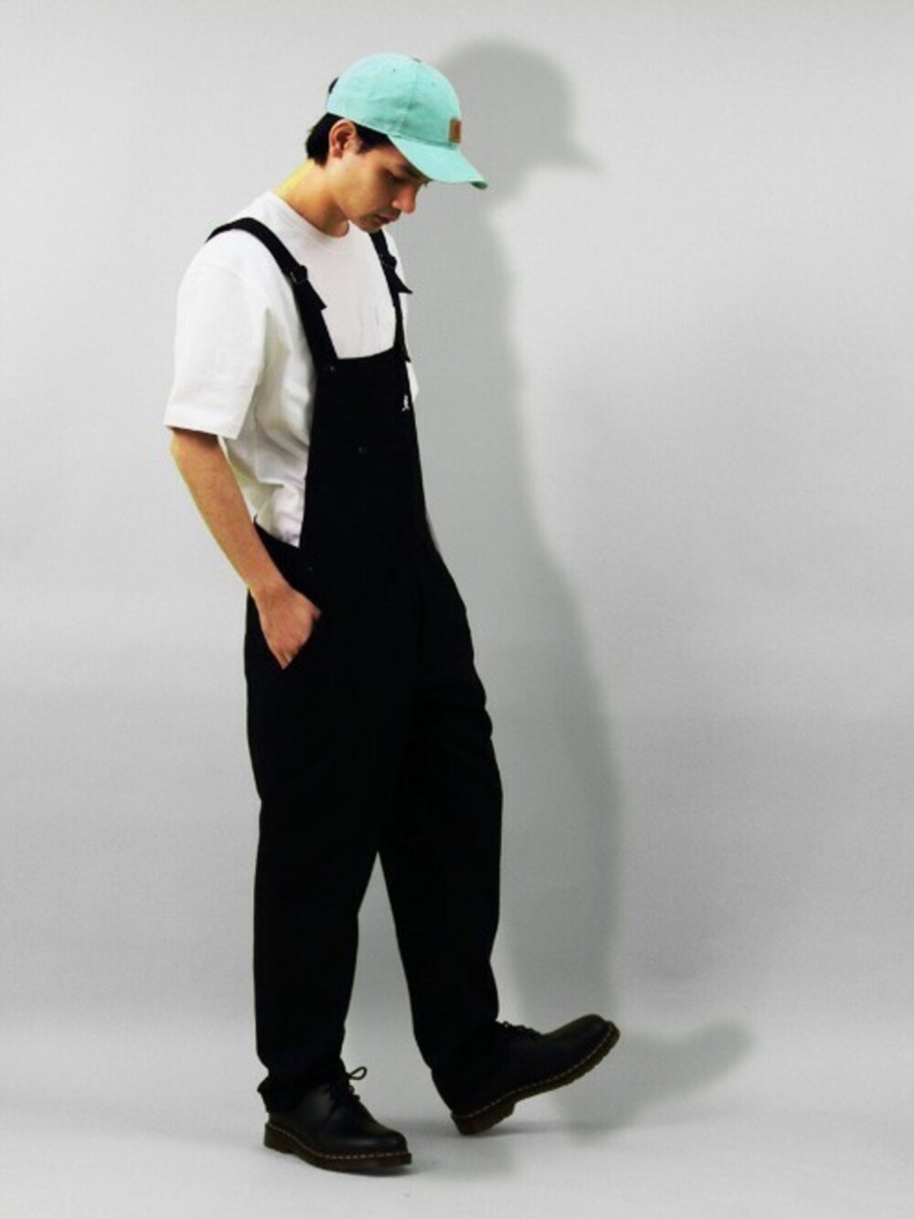 ホワイト系のTシャツ/カットソー、ブラック系のサロペット/オーバーオール、ブラック系のブーツを着用したメンズの夏コーディネートの1枚目の写真