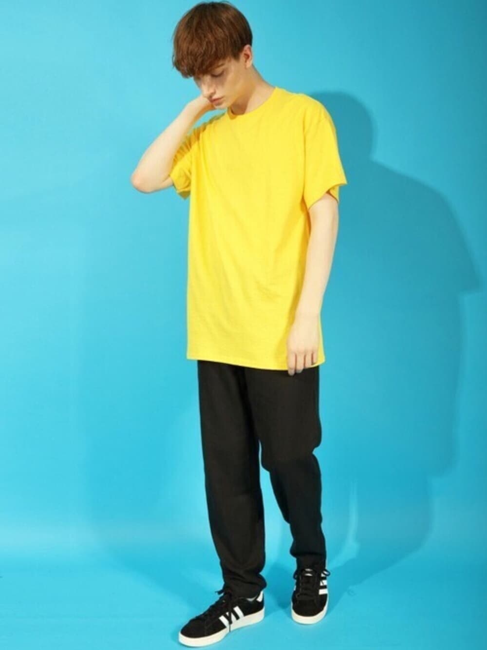 イエロー系のTシャツ/カットソー、ブラック系のチノパンツを着用したメンズの秋コーディネートの1枚目の写真