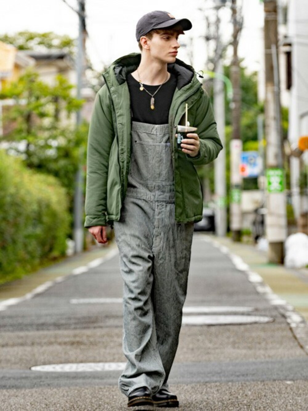 グリーン系のダウンジャケット/コート、ブラック系のTシャツ/カットソー、その他のサロペット/オーバーオールを着用したメンズの秋コーディネートの1枚目の写真