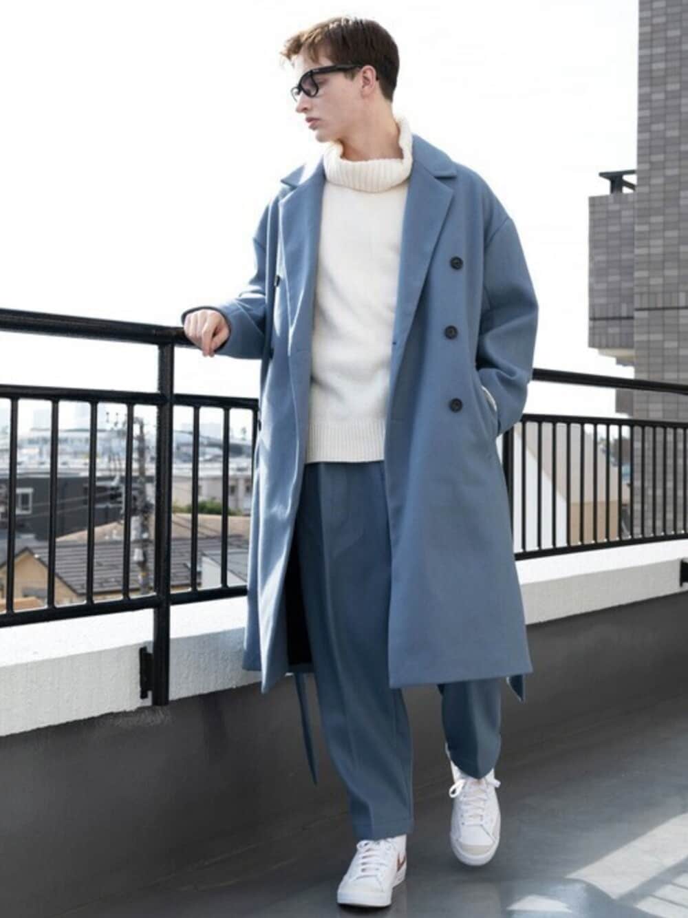 ブラウン系のチェスターコート、ホワイト系のニット/セーター、ブルー系のスラックスを着用したメンズの冬コーディネートの1枚目の写真