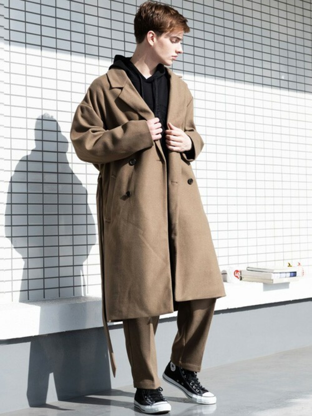 ブラウン系のチェスターコート、ブラック系のパーカー、ホワイト系のTシャツ/カットソーを着用したメンズの冬コーディネートの1枚目の写真