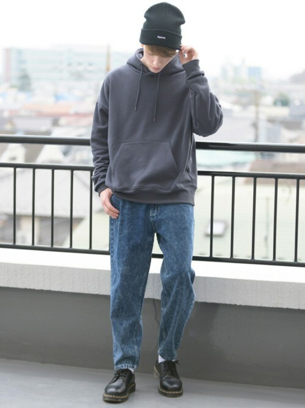 グレー系のパーカー、ホワイト系のTシャツ/カットソー、ブルー系のデニムパンツを着用したメンズの冬コーディネートの1枚目の写真