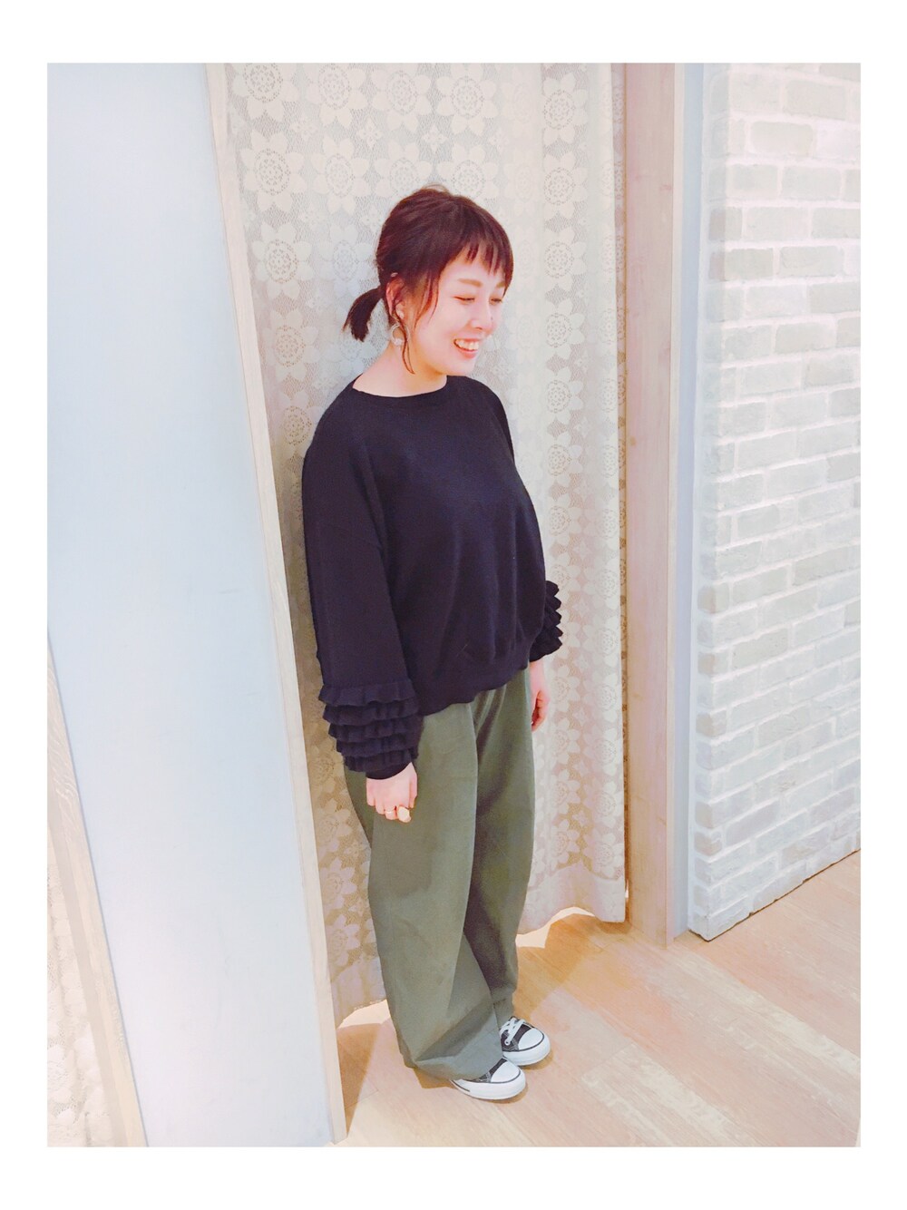 ブラック系のニット/セーター、グリーン系のチノパンツを着用したレディースの秋コーディネートの1枚目の写真