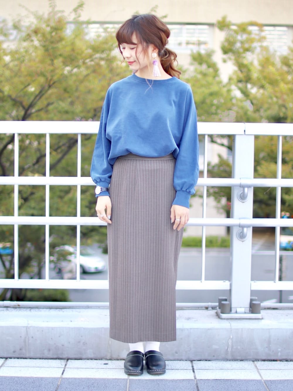 グレー系のスカート、ブルー系のTシャツ/カットソー、ブラック系のその他シューズを着用したレディースの秋コーディネートの1枚目の写真