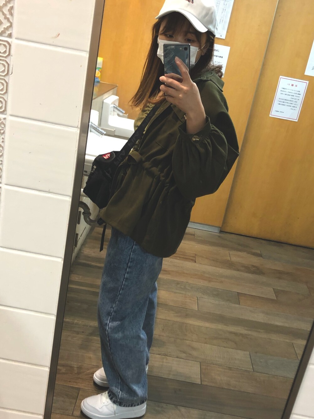 ブラック系のショルダーバッグ、シルバー系のデニムパンツ、グリーン系のデニムジャケットを着用したレディースの冬コーディネートの1枚目の写真