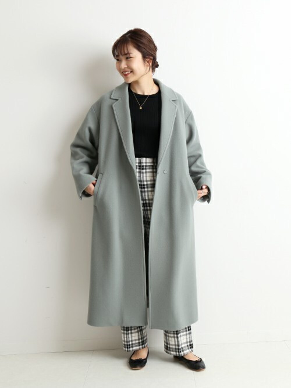 グリーン系のその他アウター、ブラック系のその他パンツ、ブラック系のニット/セーターを着用したレディースの冬コーディネートの1枚目の写真