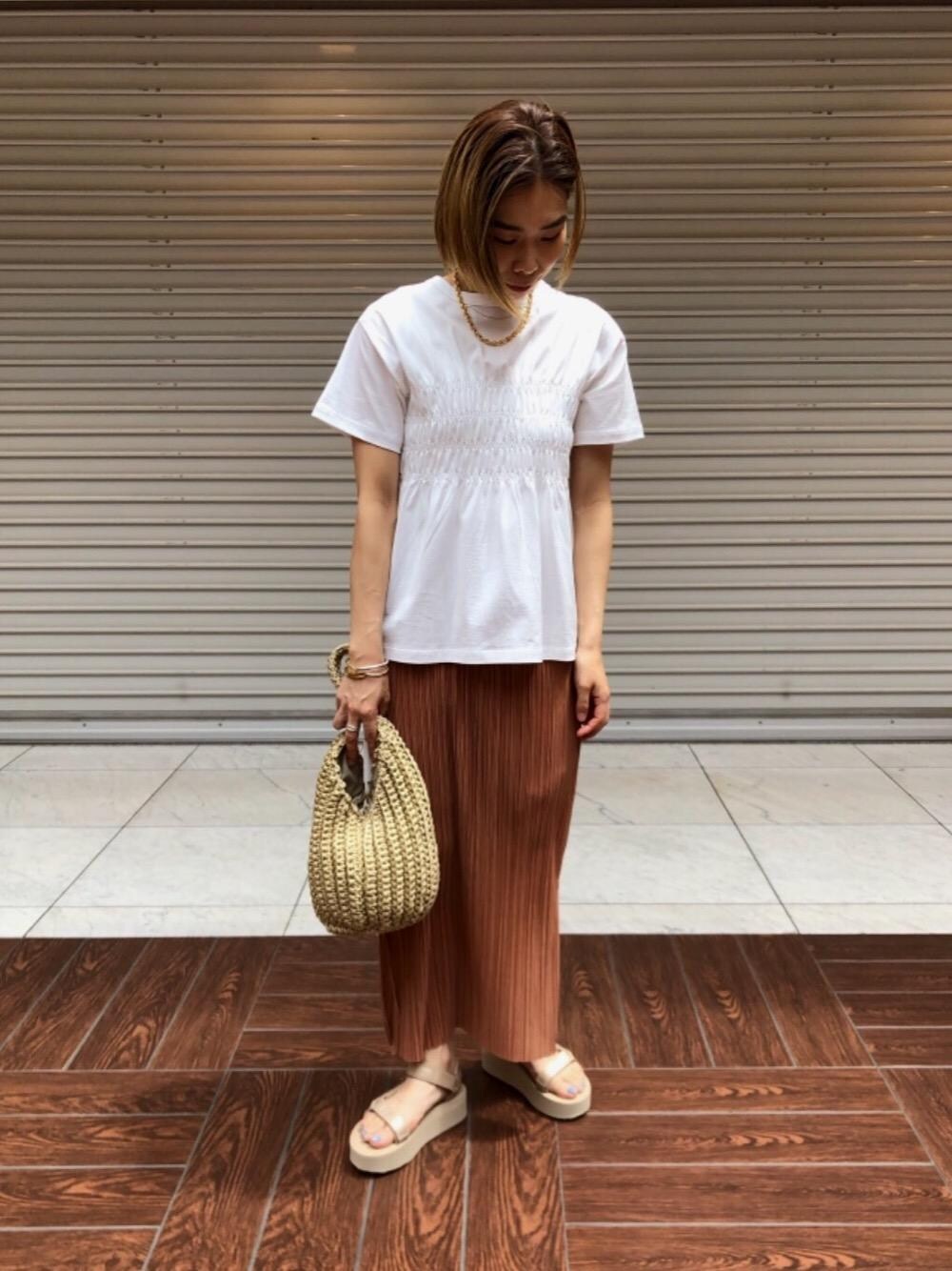 ゴールド系のサンダル、ベージュ系のショルダーバッグ、ピンク系のスカートを着用したレディースの春コーディネートの1枚目の写真