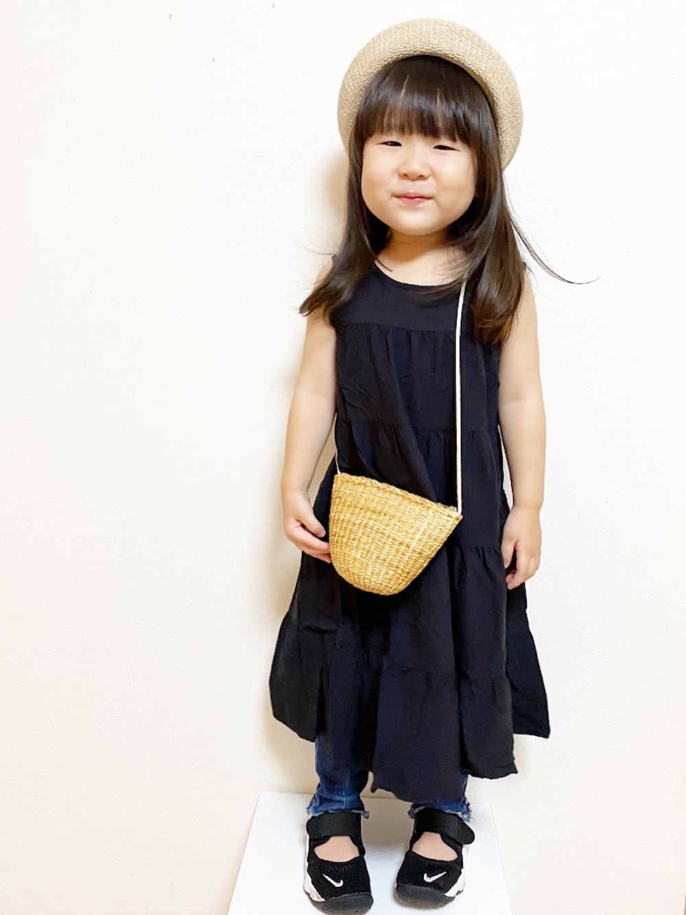 ブラック系のワンピース、ブルー系のデニムパンツ、ブラック系のスニーカーを着用したキッズの夏コーディネートの1枚目の写真