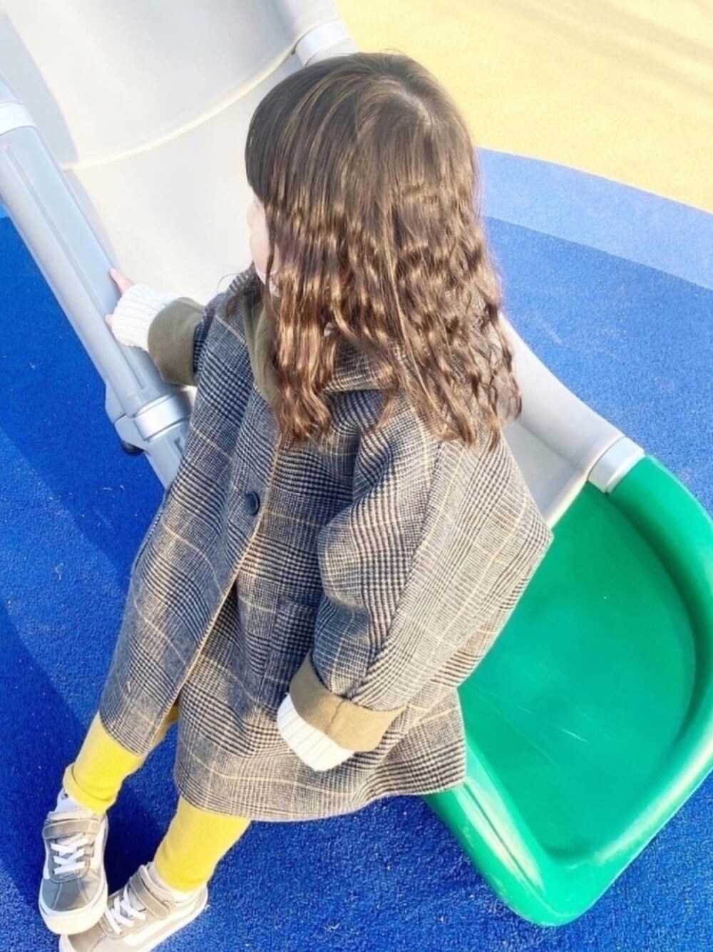 グレー系のその他アウター、ホワイト系のニット/セーター、グレー系のスニーカーを着用したキッズの冬コーディネートの1枚目の写真