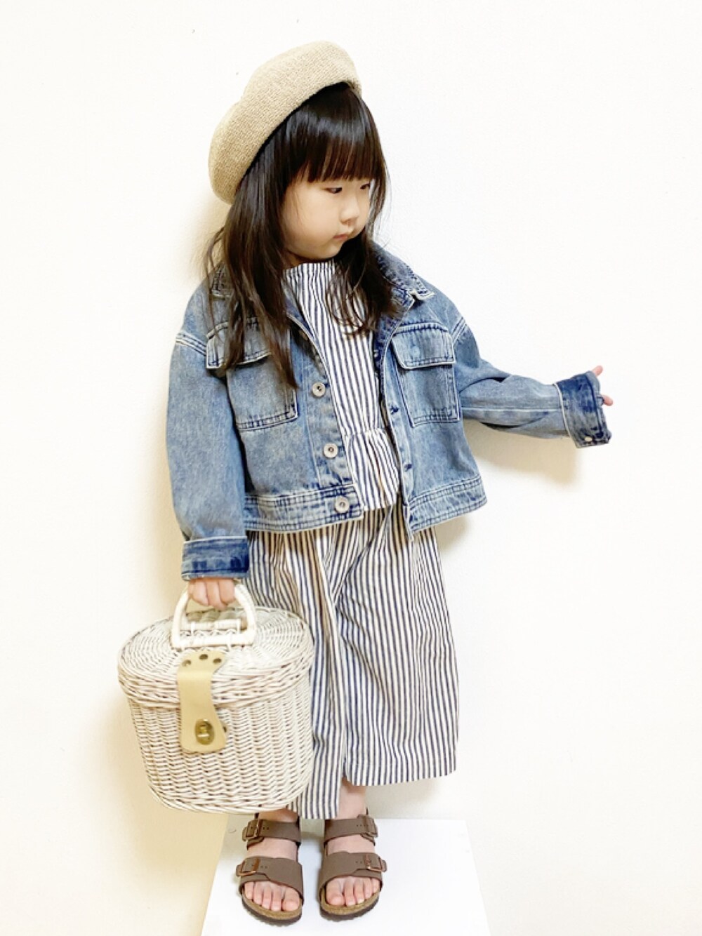 ブルー系のデニムジャケット、ブラウン系のサンダル、ベージュ系のハンチング/ベレー帽を着用したキッズの春コーディネートの1枚目の写真