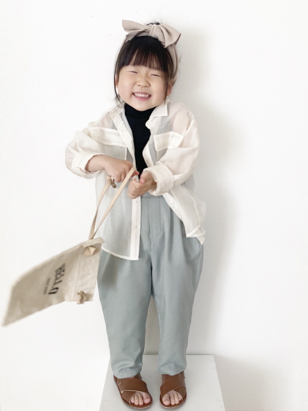 ベージュ系のシャツ/ブラウス、ブラック系のトップス、グリーン系のその他パンツを着用したキッズの春コーディネートの1枚目の写真