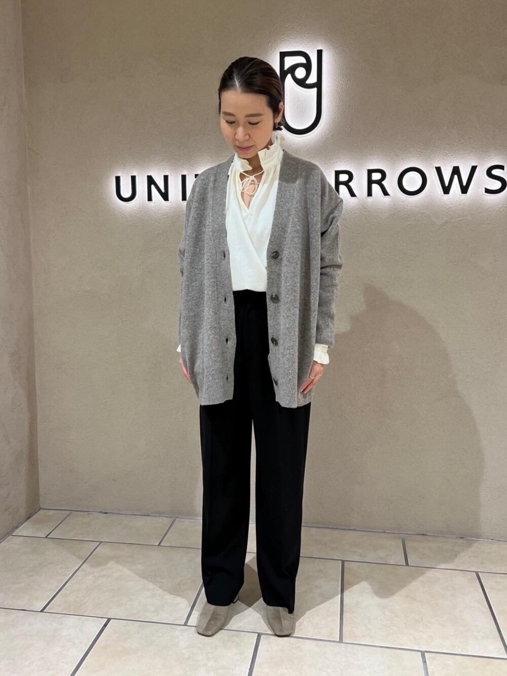 ブラウン系のブーツ、ブラウン系のカーディガン/ボレロ、ブラック系のその他パンツを着用したレディースの秋コーディネートの1枚目の写真