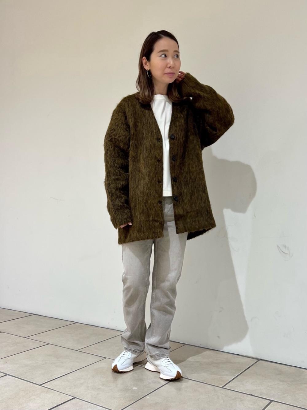 ブラウン系のデニムパンツ、ホワイト系のスニーカーを着用したレディースの秋コーディネートの1枚目の写真