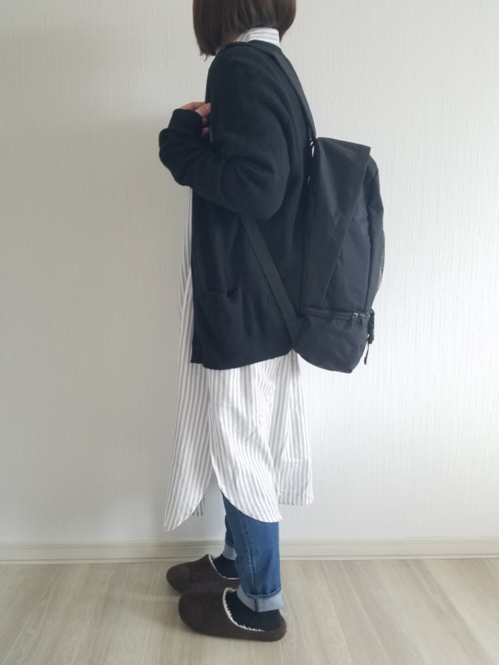 ブラック系のカーディガン/ボレロ、ブラック系のバックパック/リュック、ブラウン系のその他シューズを着用したレディースの春コーディネートの1枚目の写真