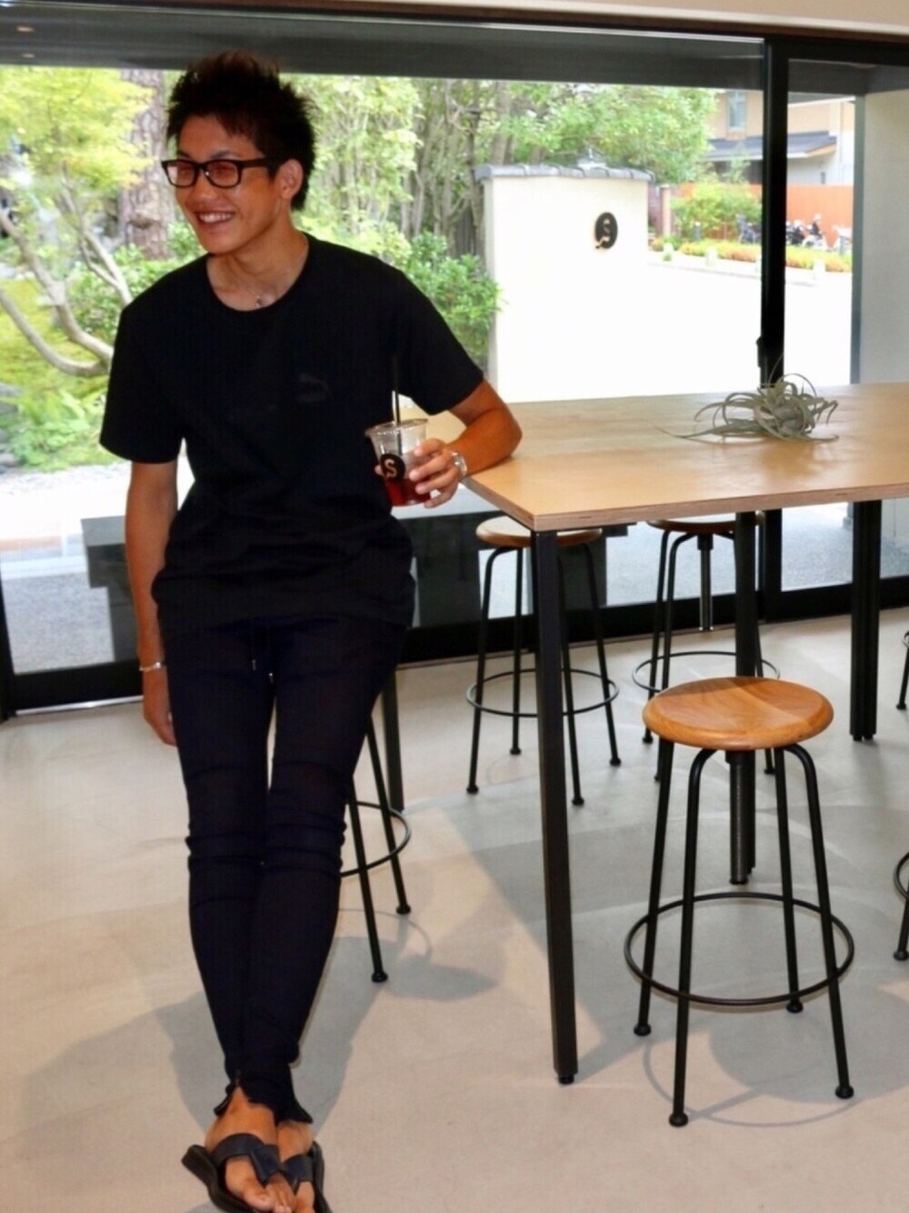 ブラック系のTシャツ/カットソー、ブルー系のデニムパンツ、ブルー系のサンダルを着用したメンズの夏コーディネートの1枚目の写真