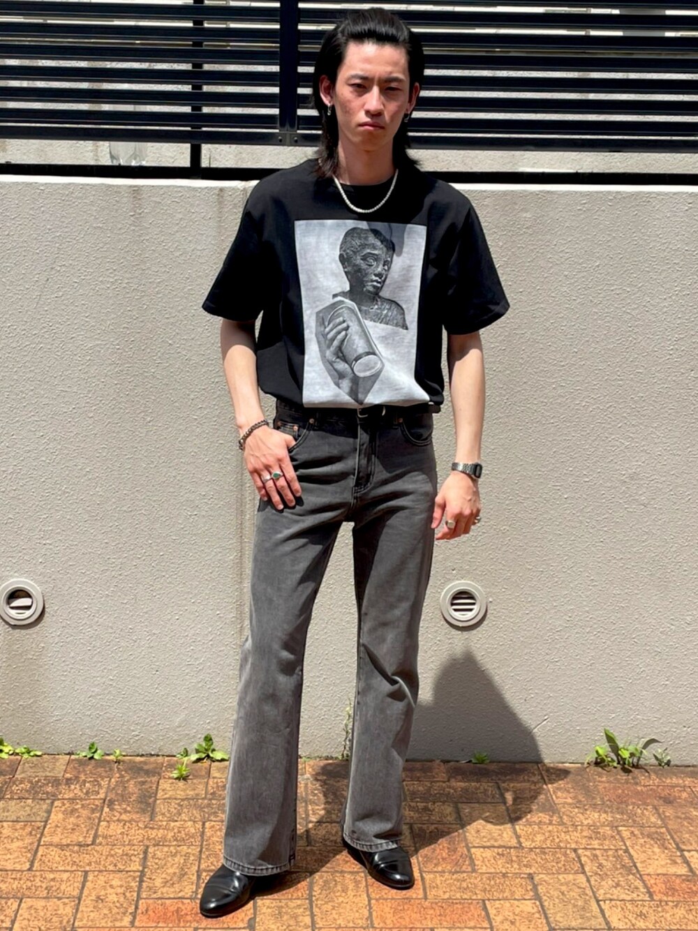 ブラック系のTシャツ/カットソー、ブラック系のデニムパンツ、ブラック系のスリッポンを着用したメンズの夏コーディネートの1枚目の写真